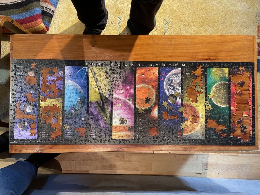 Top-down photo of an almost-complete 1000 piece jigsaw of the solar system.